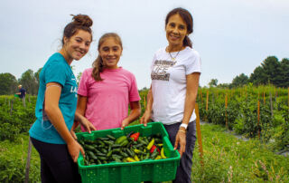 Mom and two daughters volunteering at Farm